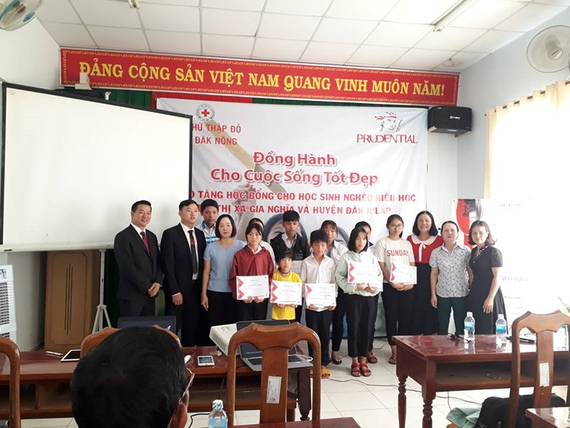 Đồng chí Trần Thị Tuyết - Chủ tịch Hội Chữ thập đỏ tỉnh Đắk Nông và đại diện công ty Prudential trao học bổng cho các em học sinh tại thị xã Gia Nghĩa
